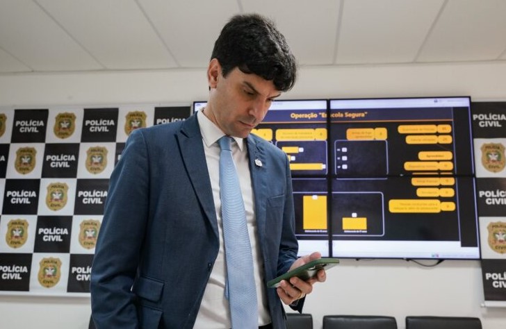 Imagem mostra delegado com celular na mao