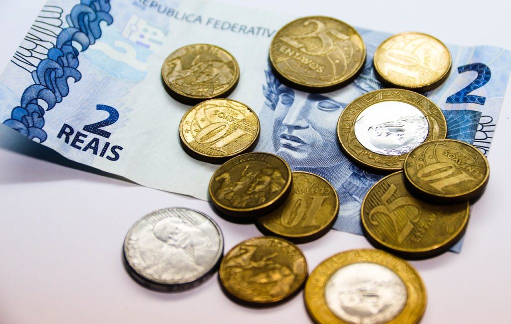 Imagem mostra moedas e nota de dois reais