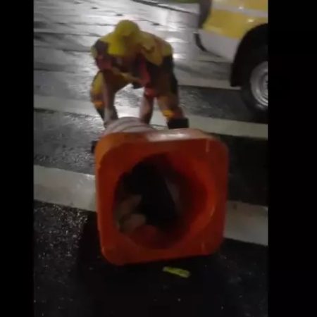 Homem fica preso em cone de trânsito em fuga da chuva